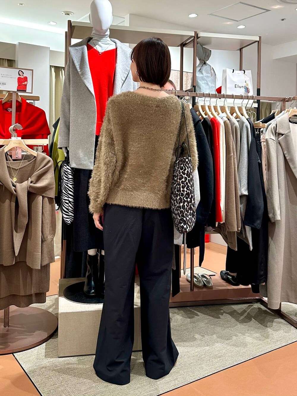 ブラック系のその他パンツ、ホワイト系のスニーカー、ブラウン系のニット/セーターを着用したレディースの冬コーディネートの4枚目の写真