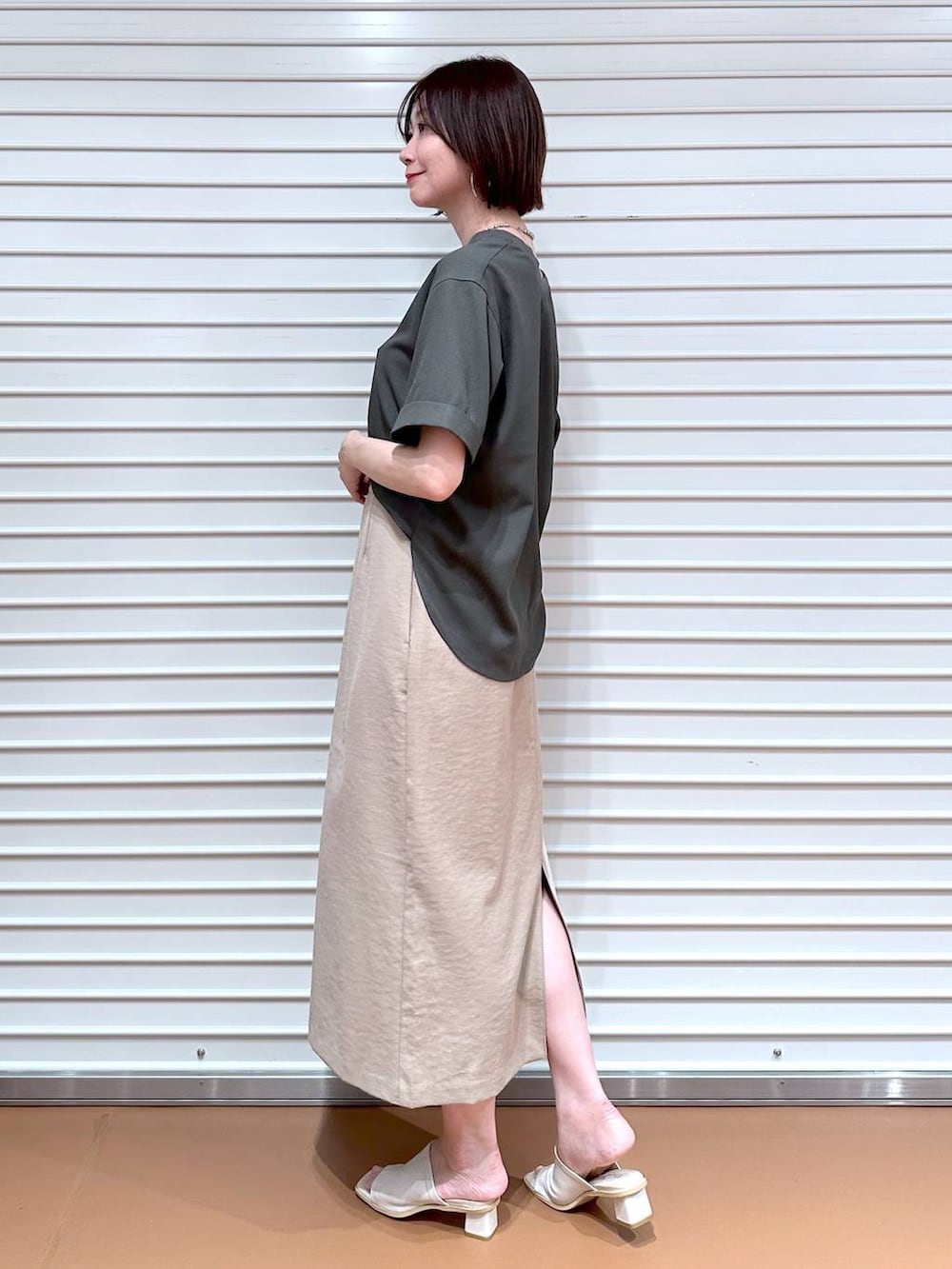 ベージュ系のスカート、グリーン系のシャツ/ブラウスを着用したレディースの夏コーディネートの2枚目の写真