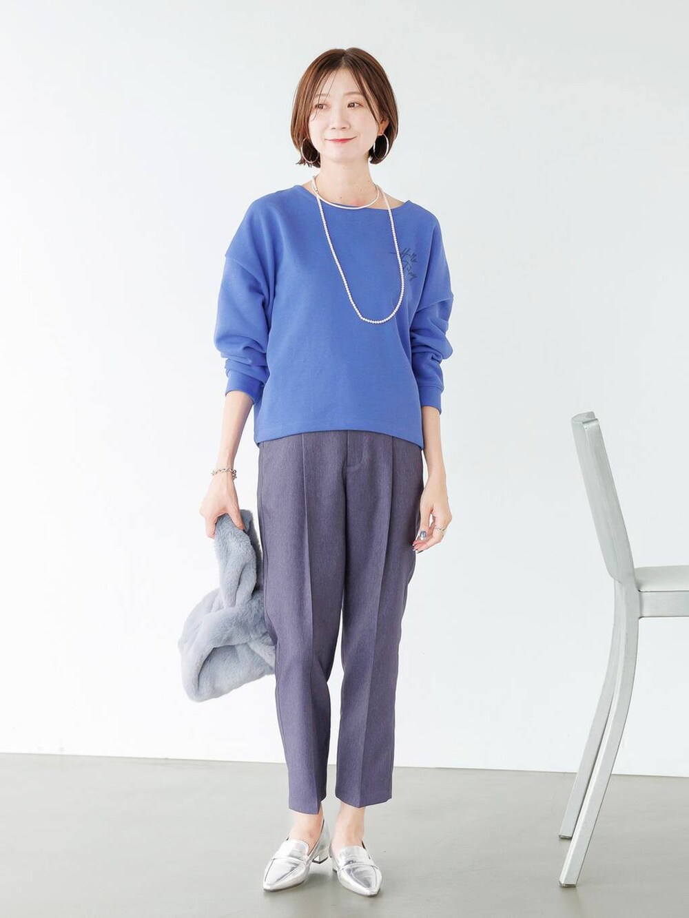 シルバー系のローファー、ブルー系のデニムパンツを着用したレディースの秋コーディネートの3枚目の写真