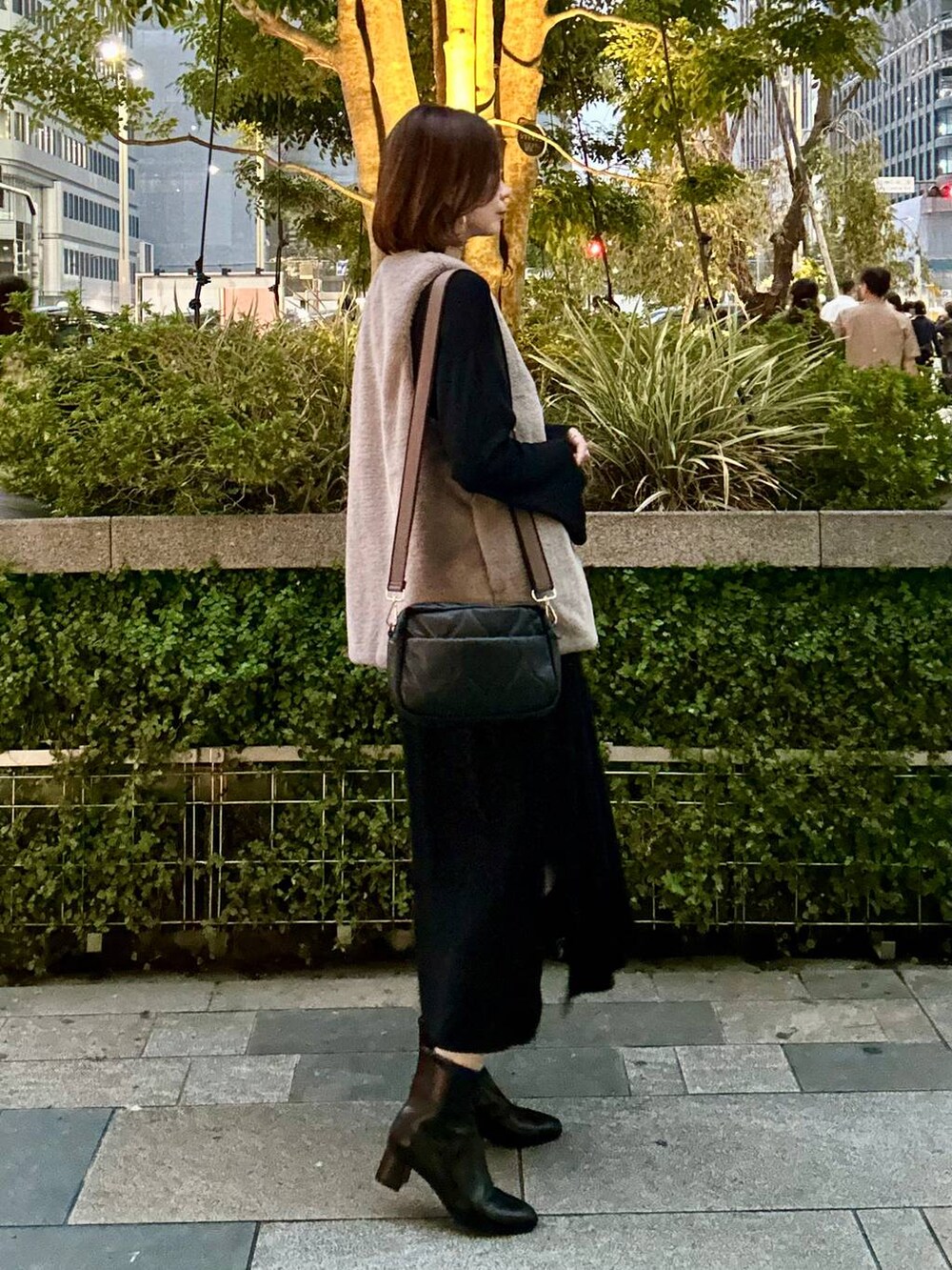 ブラック系のブーツ、ブラウン系のベスト、シルバー系のネックレスを着用したレディースの秋コーディネートの4枚目の写真