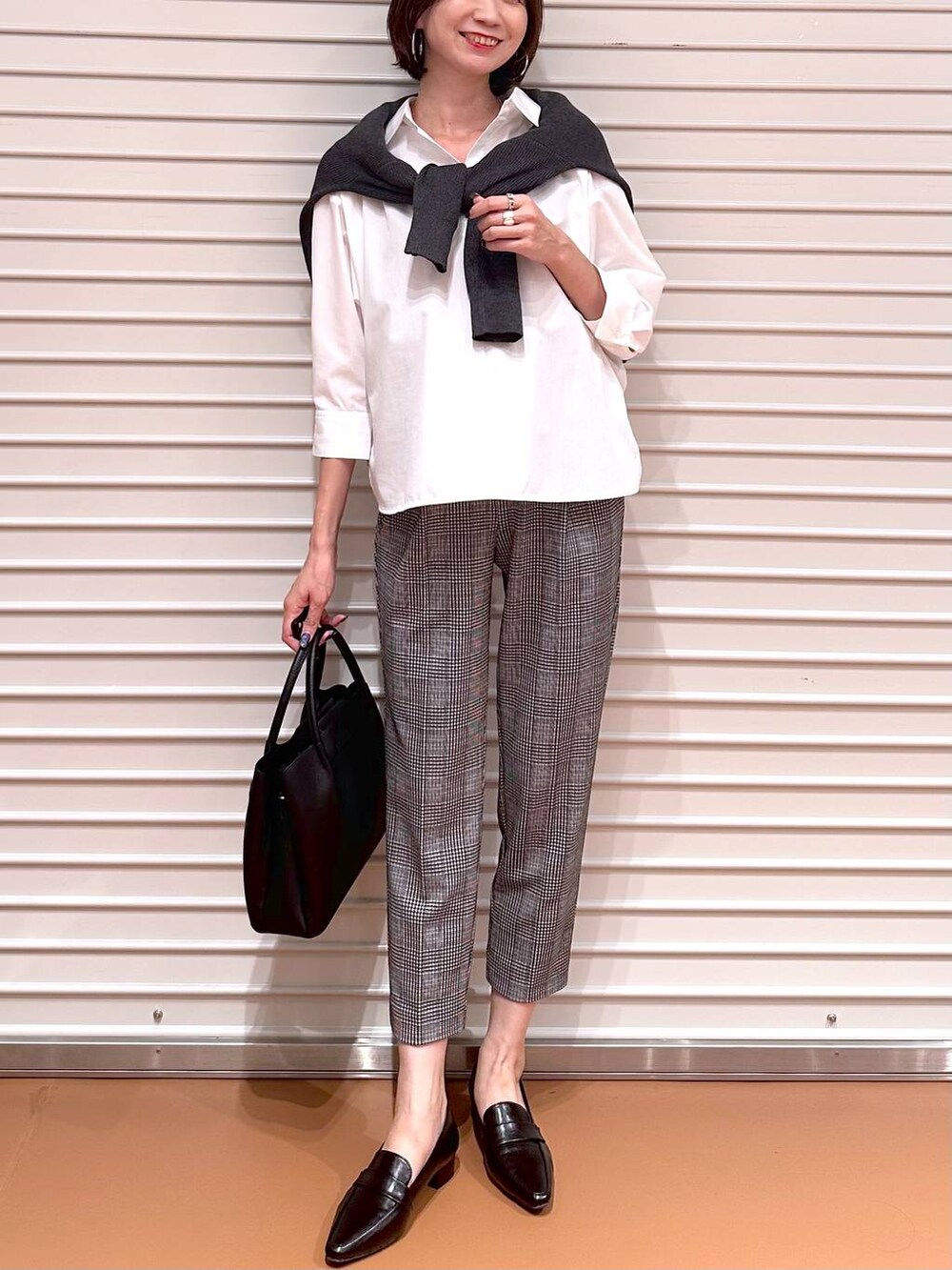 グレー系のニット/セーター、ブラック系のその他パンツ、ブラック系のハンドバッグを着用したレディースの秋コーディネートの5枚目の写真