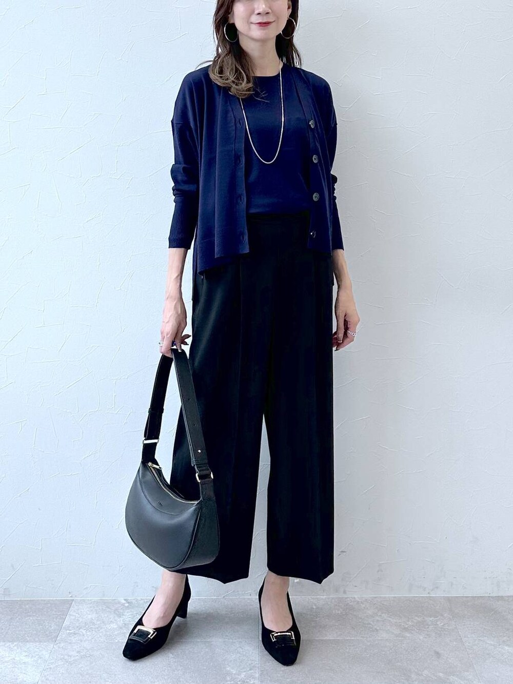 グレー系のパンプス、ブルー系のその他パンツ、ブラック系のハンドバッグを着用したレディースの冬コーディネートの5枚目の写真