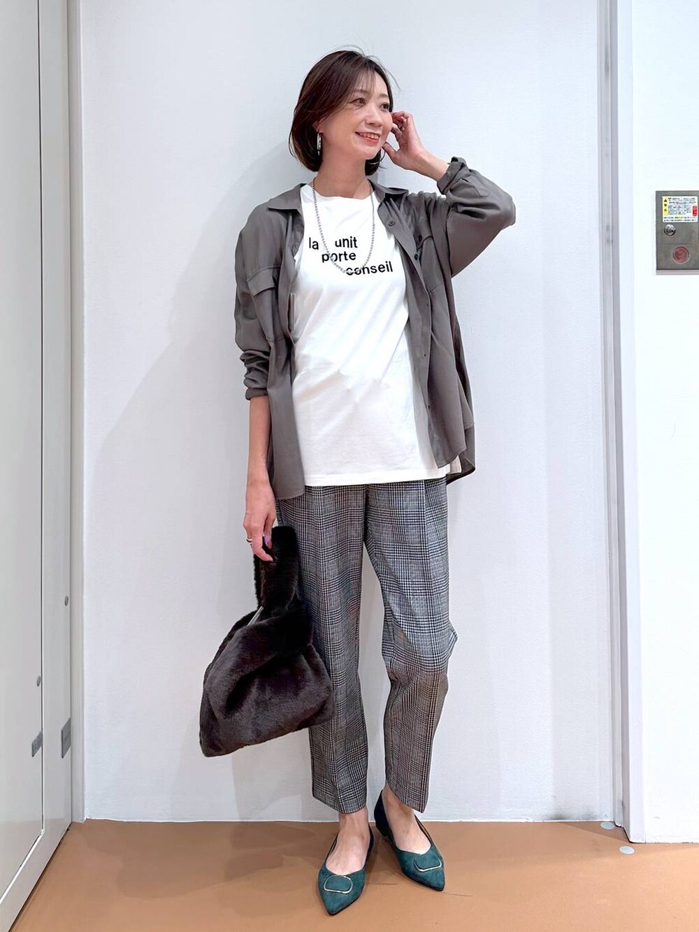 グレー系のシャツ/ブラウス、ブラック系のその他パンツ、グリーン系のパンプスを着用したレディースの秋コーディネートの2枚目の写真