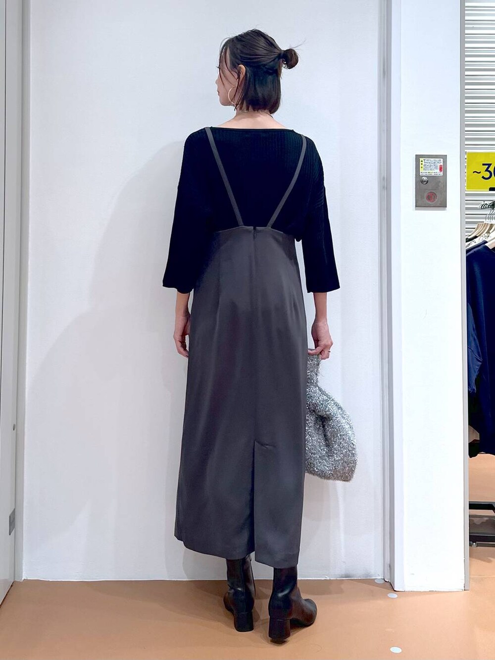 ブラック系のニット/セーター、グレー系のスカート、シルバー系のネックレスを着用したレディースの秋コーディネートの4枚目の写真