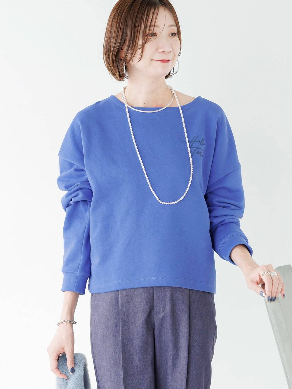 シルバー系のローファー、ブルー系のデニムパンツを着用したレディースの秋コーディネートの6枚目の写真