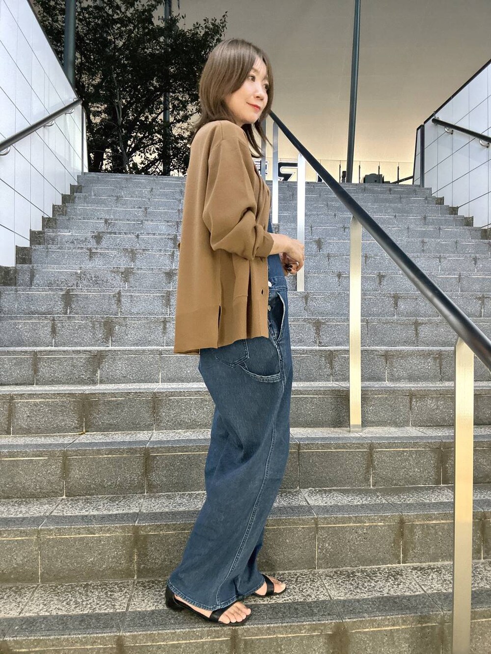 ブラウン系のニット/セーター、ブラウン系のカーディガン/ボレロ、ブルー系のサロペット/オーバーオールを着用したレディースの夏コーディネートの6枚目の写真