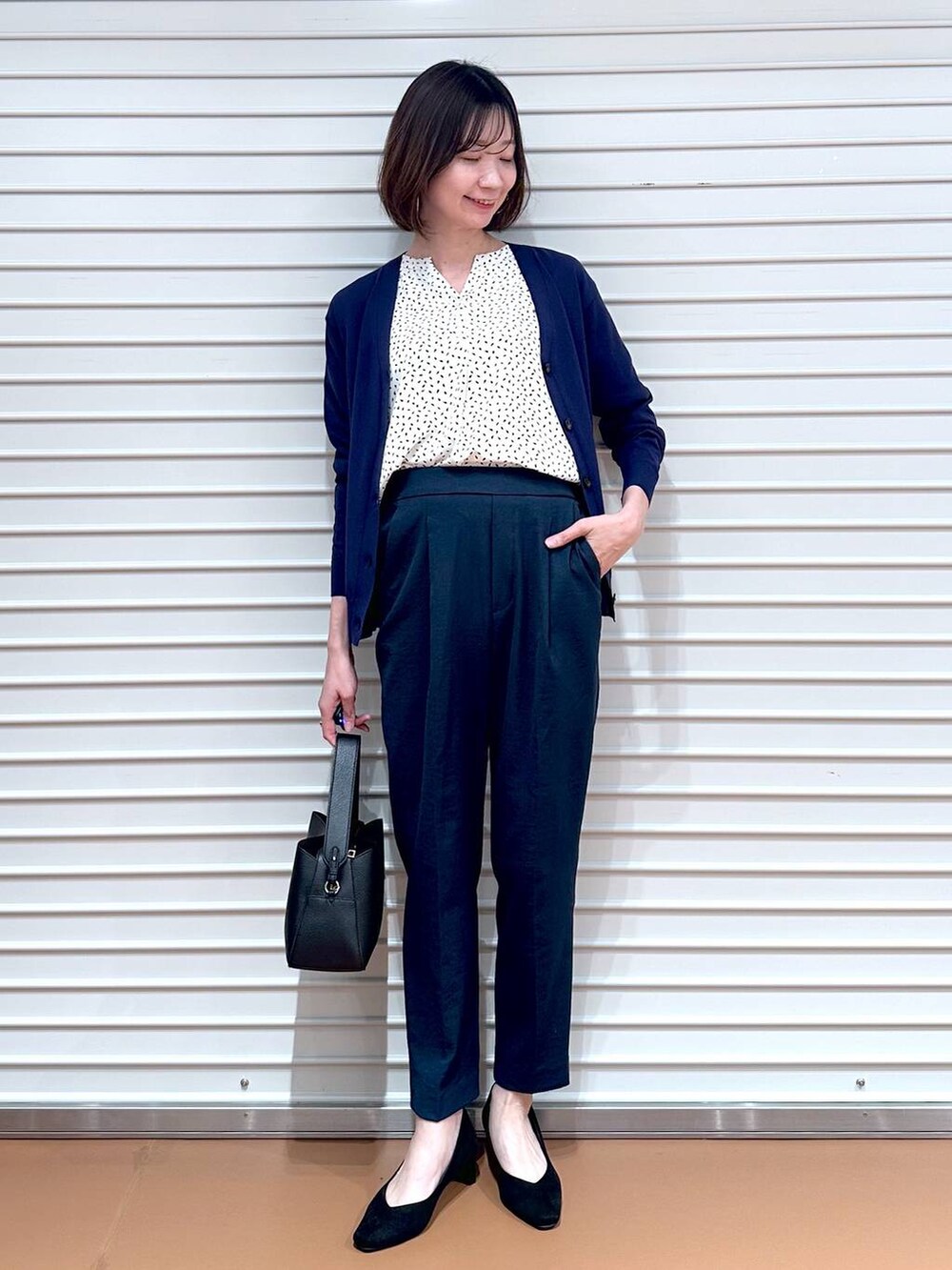 ホワイト系のシャツ/ブラウス、ブルー系のカーディガン/ボレロ、ブラック系のハンドバッグを着用したレディースの夏コーディネートの2枚目の写真