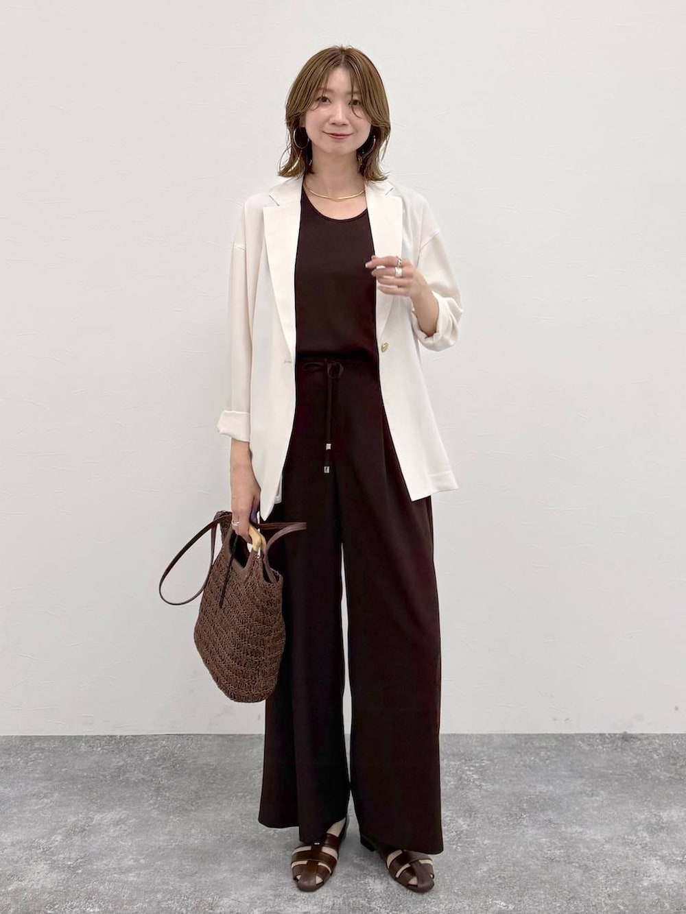 ブラウン系のパンプス、ブラウン系のその他パンツ、ホワイト系のテーラードジャケットを着用したレディースの春コーディネートの2枚目の写真