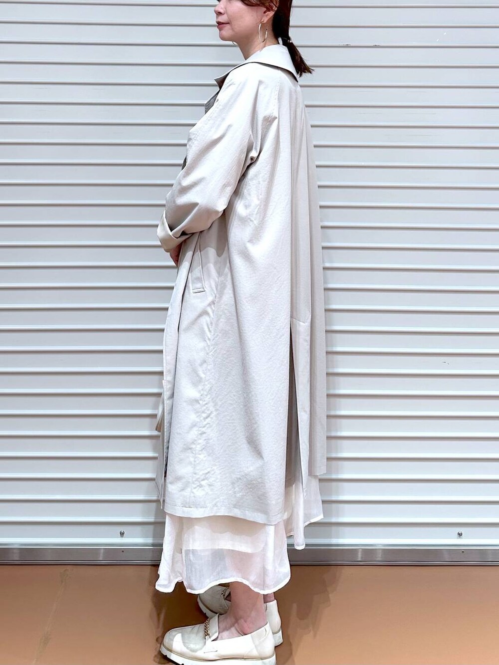 ホワイト系のスカート、ホワイト系のローファー、ホワイト系のハンドバッグを着用したレディースの冬コーディネートの5枚目の写真