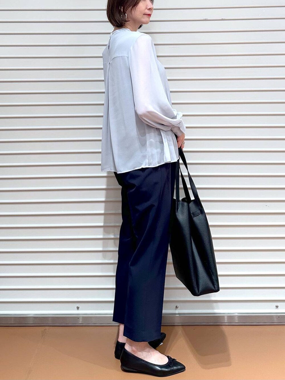 ブルー系のその他パンツ、ブラック系のトートバッグ、ブラック系のパンプスを着用したレディースの秋コーディネートの6枚目の写真