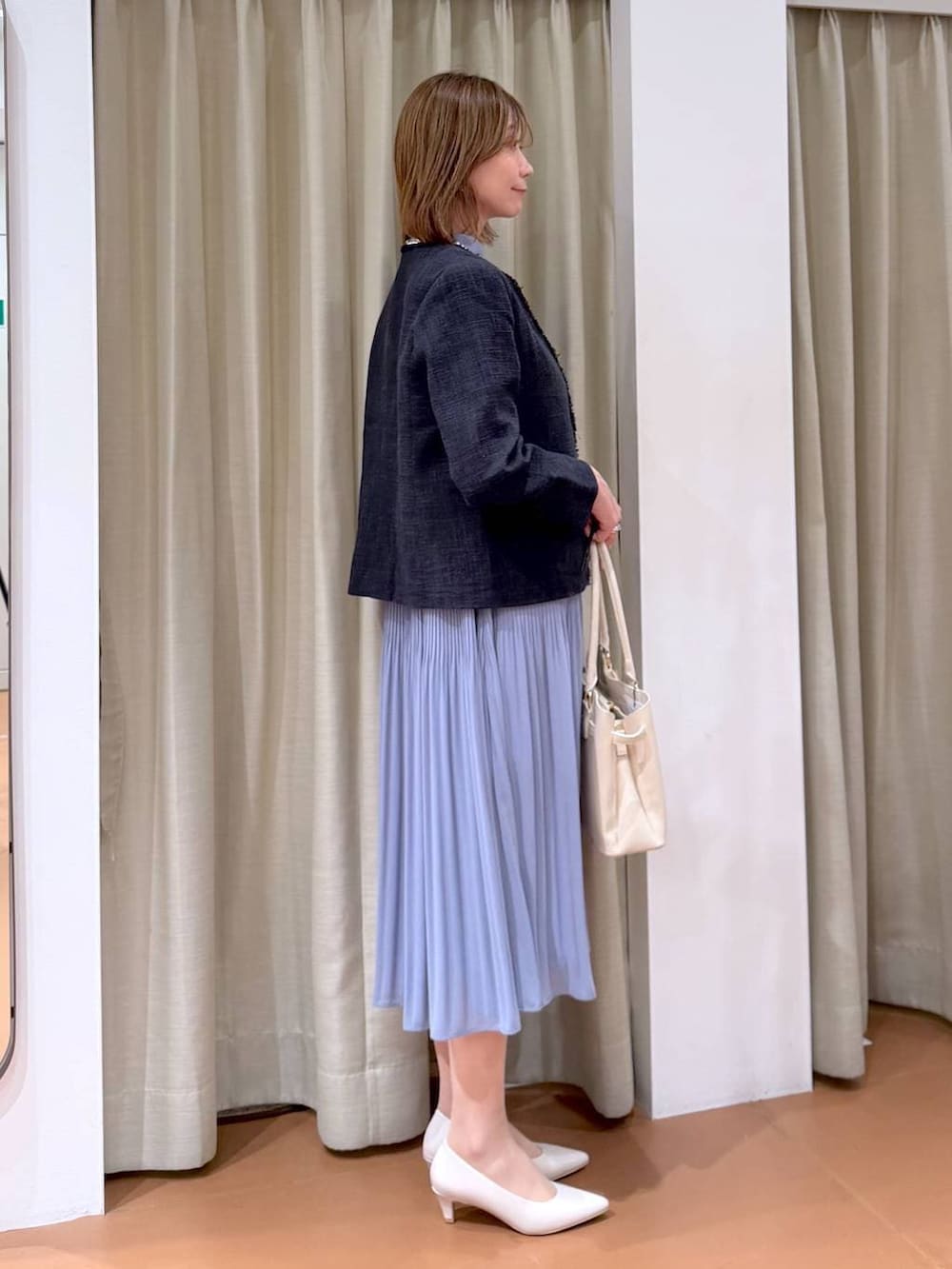ベージュ系のパンプス、ブルー系のノーカラージャケット、ブルー系のワンピースを着用したレディースの冬コーディネートの5枚目の写真