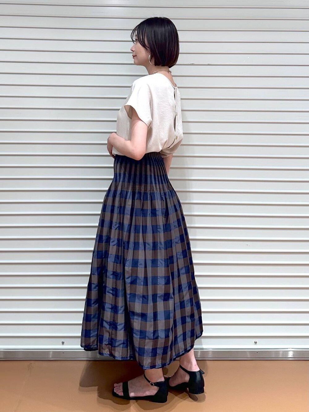 ベージュ系のシャツ/ブラウス、ブラウン系のスカート、ブラック系のサンダルを着用したレディースの夏コーディネートの3枚目の写真