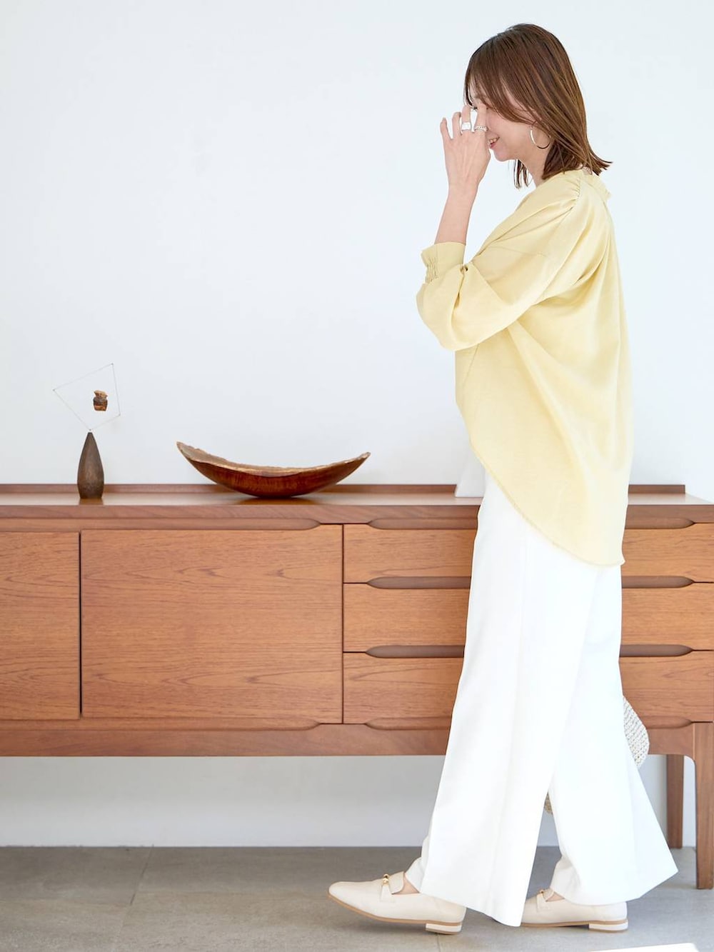 イエロー系のシャツ/ブラウス、ホワイト系のパンプスを着用したレディースの春コーディネートの3枚目の写真