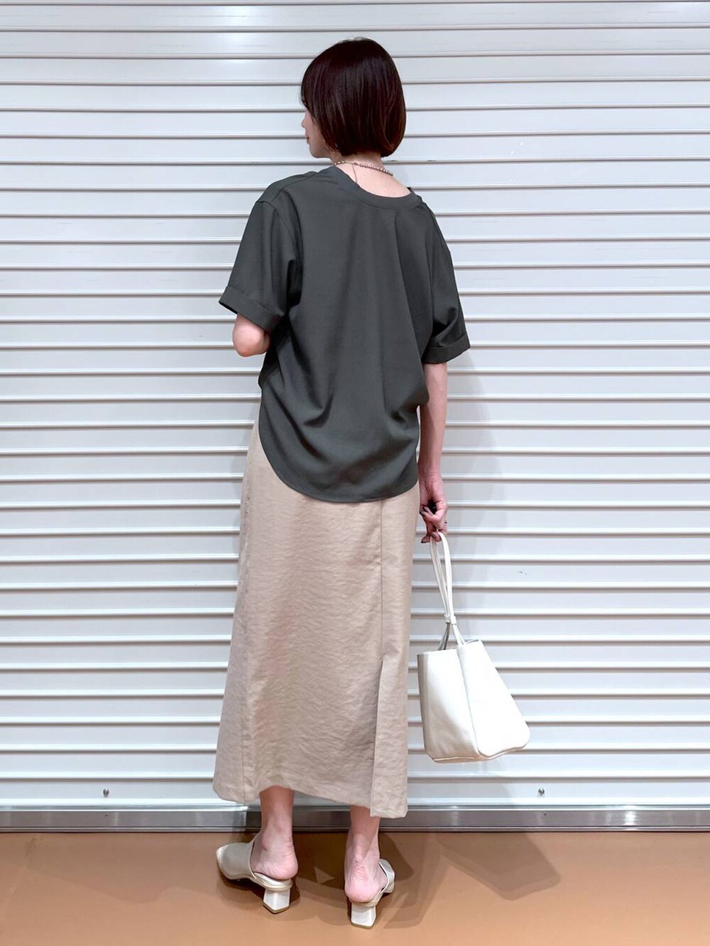 ベージュ系のスカート、グリーン系のシャツ/ブラウスを着用したレディースの夏コーディネートの3枚目の写真