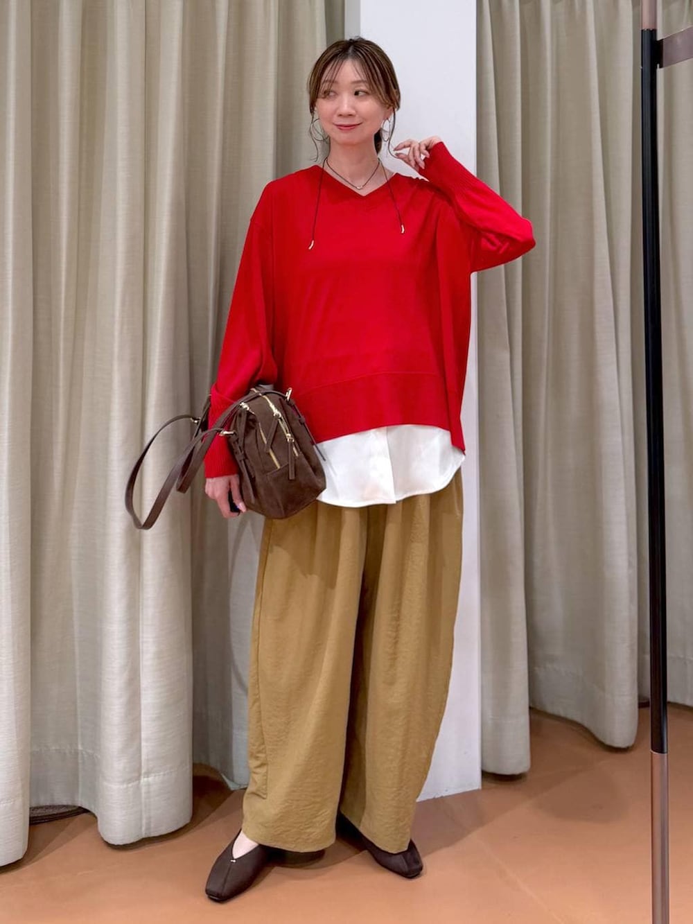 ブラウン系のパンプス、ブラウン系のボストンバッグ、イエロー系のその他パンツを着用したレディースの春コーディネートの2枚目の写真