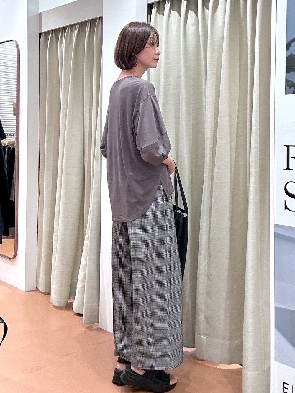 ブラック系のサンダル、ブラック系のその他パンツ、ブラック系のトートバッグを着用したレディースの秋コーディネートの5枚目の写真