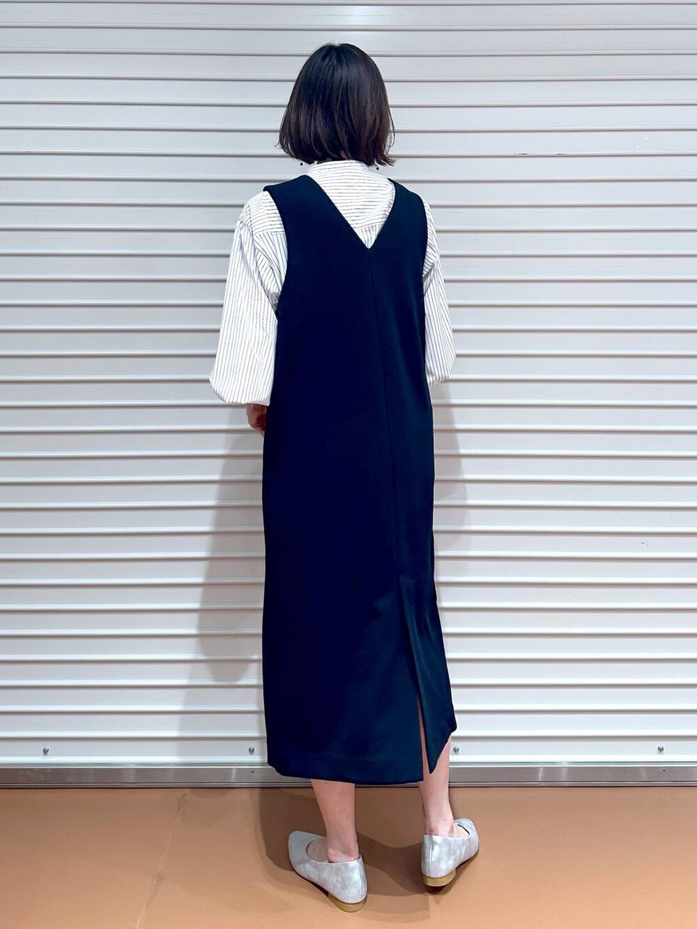 イエロー系のハンドバッグ、ブラック系のジャンパースカート、ブラック系のジャンパースカートを着用したレディースの春コーディネートの3枚目の写真