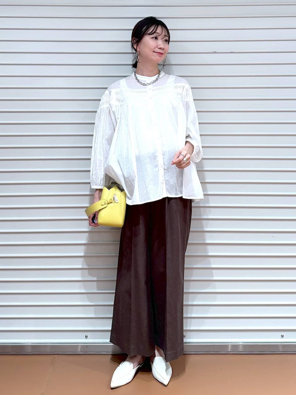 ブラウン系のその他パンツ、ブラウン系のその他パンツ、イエロー系のハンドバッグを着用したレディースの夏コーディネートの2枚目の写真