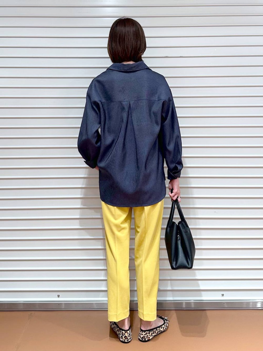 イエロー系のその他パンツ、ブラック系のハンドバッグ、ブラウン系のパンプスを着用したレディースの夏コーディネートの4枚目の写真