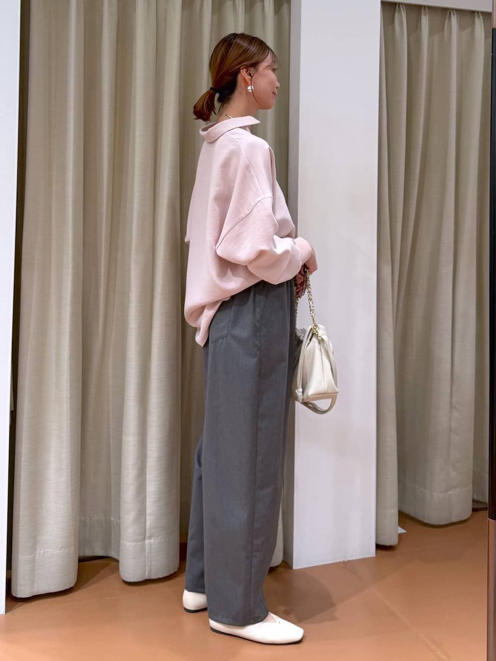 ホワイト系のハンドバッグ、ホワイト系のパンプス、グレー系のその他パンツを着用したレディースの冬コーディネートの5枚目の写真