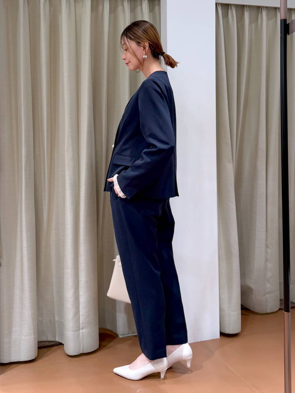 ホワイト系のパンプス、ホワイト系のTシャツ/カットソー、ブルー系のノーカラージャケットを着用したレディースの冬コーディネートの3枚目の写真