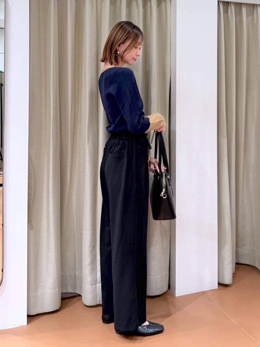 ブラック系のその他パンツ、ブラック系のパンプス、ブルー系のニット/セーターを着用したレディースの冬コーディネートの3枚目の写真