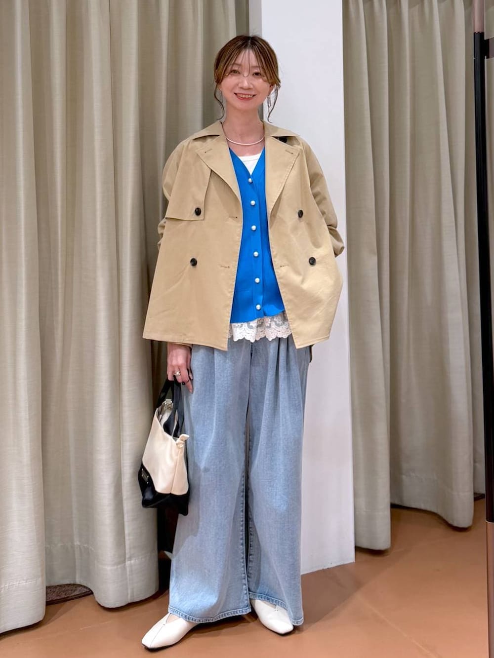 ホワイト系のパンプス、ホワイト系のタンクトップ、ブルー系のデニムパンツを着用したレディースの春コーディネートの2枚目の写真