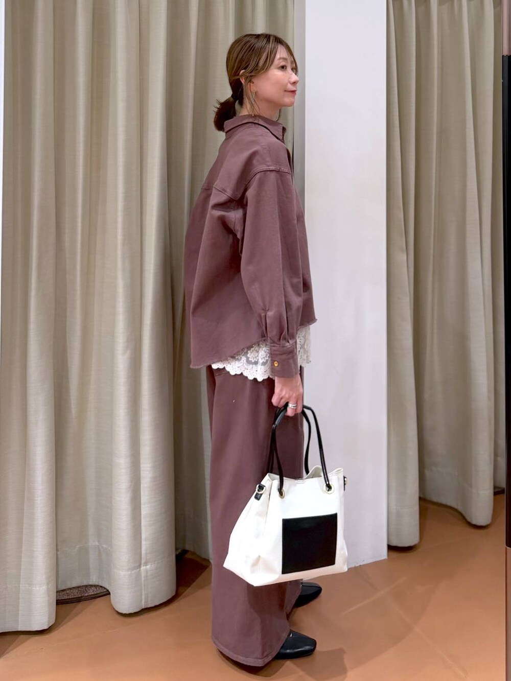 ブラック系のパンプス、ホワイト系のタンクトップ、ブラウン系のデニムパンツを着用したレディースの冬コーディネートの5枚目の写真