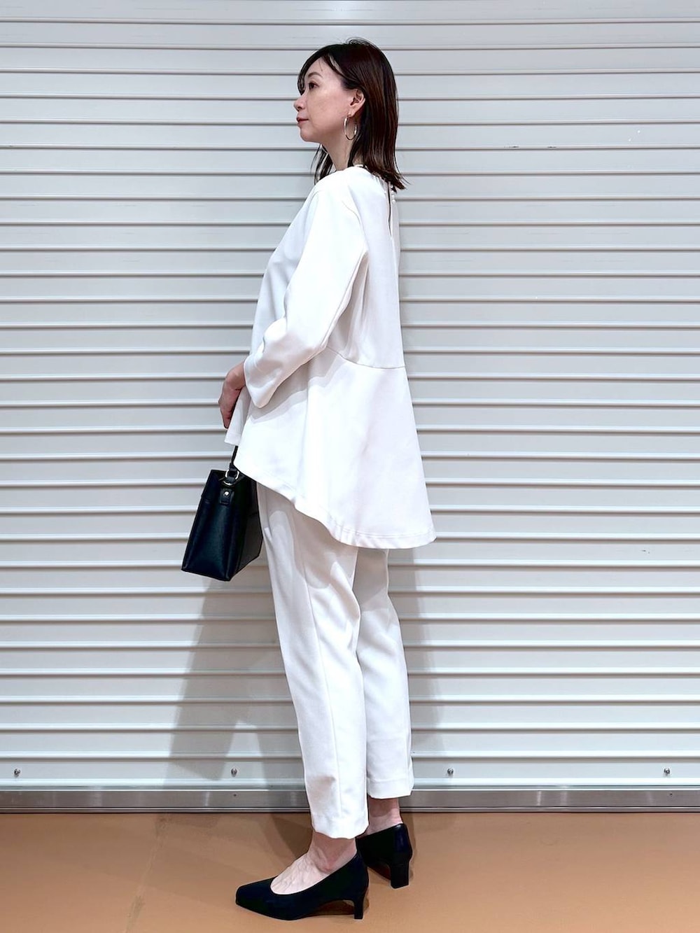 ベージュ系のその他パンツ、ベージュ系のシャツ/ブラウス、ブラック系のハンドバッグを着用したレディースの冬コーディネートの3枚目の写真