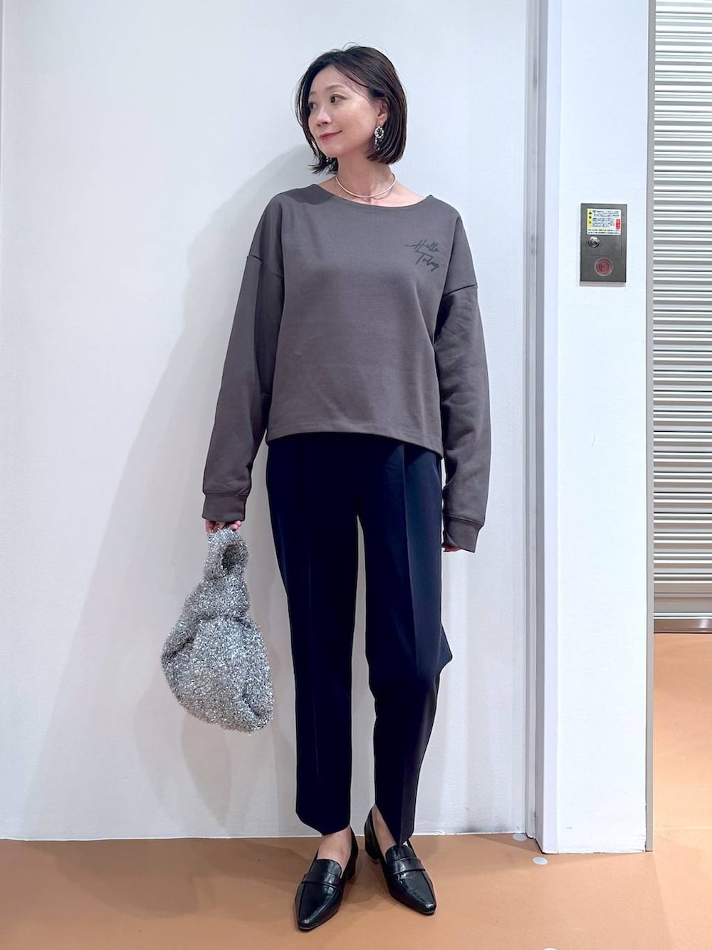 ブルー系のその他パンツ、ブラック系のローファー、シルバー系のハンドバッグを着用したレディースの秋コーディネートの2枚目の写真