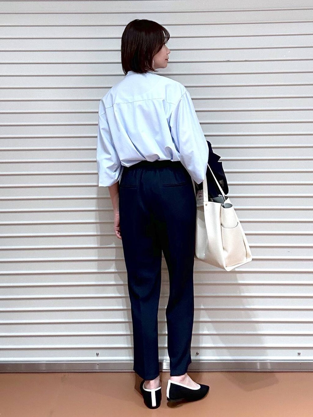 ブラック系のパンプス、ホワイト系のトートバッグ、ブルー系のその他パンツを着用したレディースの春コーディネートの6枚目の写真
