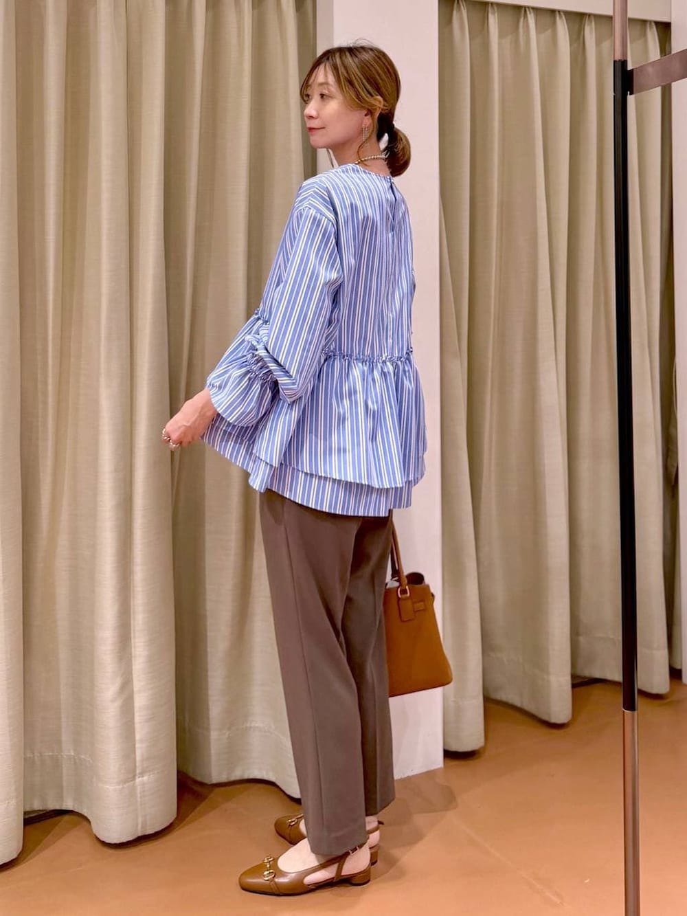 ブラウン系のその他パンツ、イエロー系のハンドバッグ、ブラウン系のパンプスを着用したレディースの春コーディネートの6枚目の写真