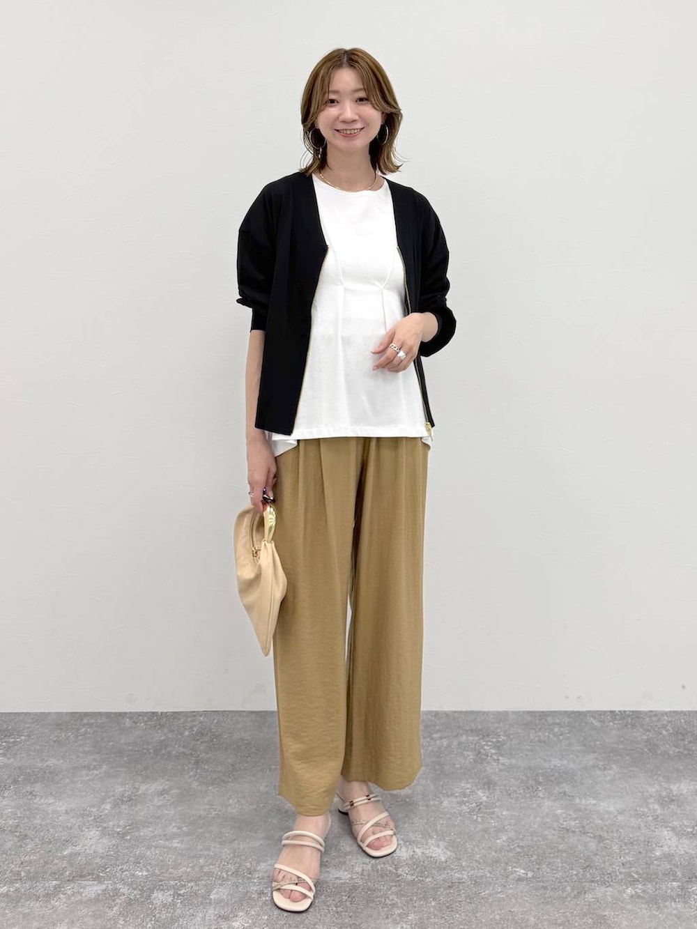 ベージュ系のその他パンツ、ブラック系のカーディガン/ボレロ、ホワイト系のTシャツ/カットソーを着用したレディースの春コーディネートの2枚目の写真