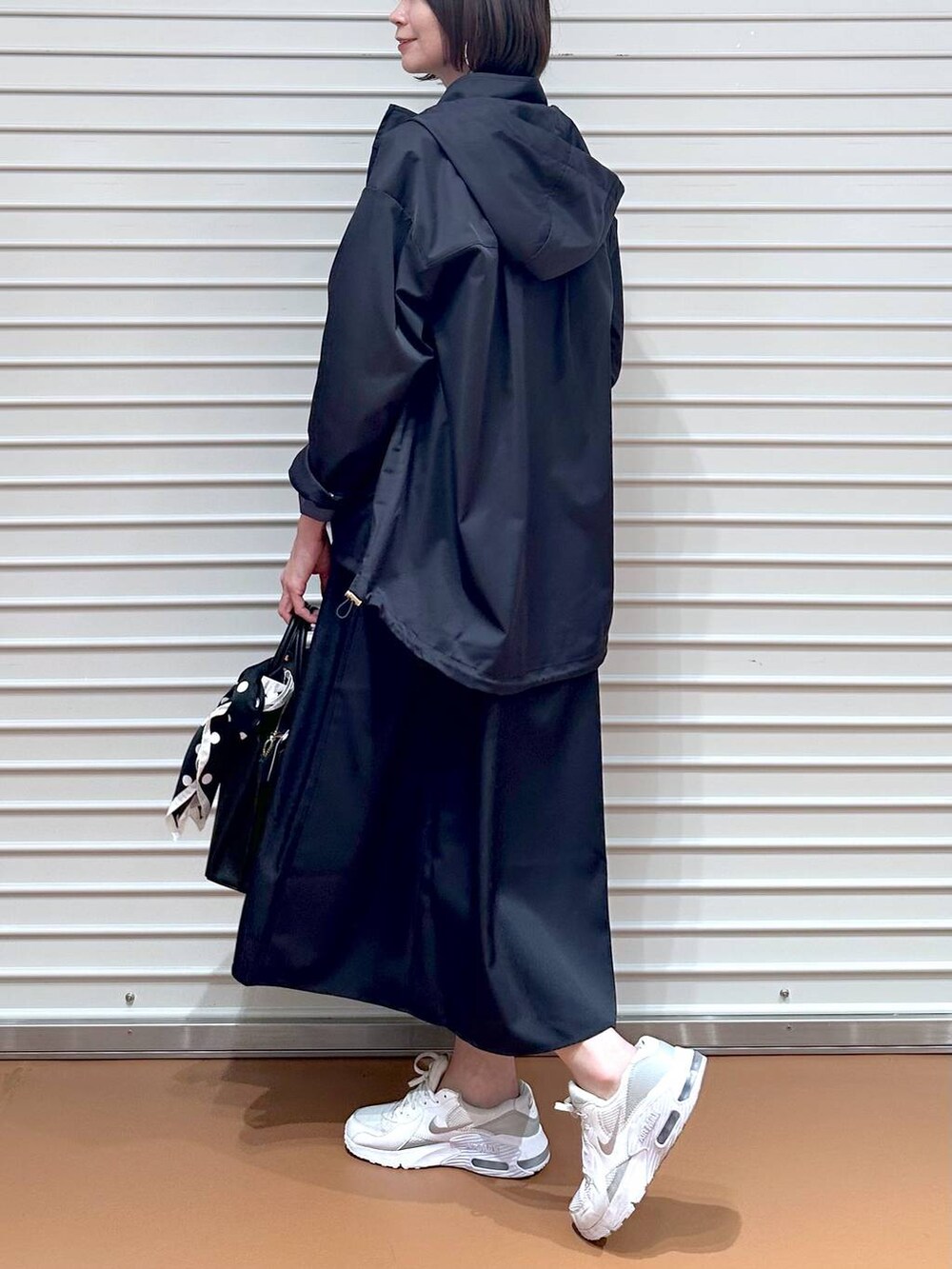 ブルー系のスカート、ブラック系のショルダーバッグ、ブルー系のシャツ/ブラウスを着用したレディースの春コーディネートの9枚目の写真