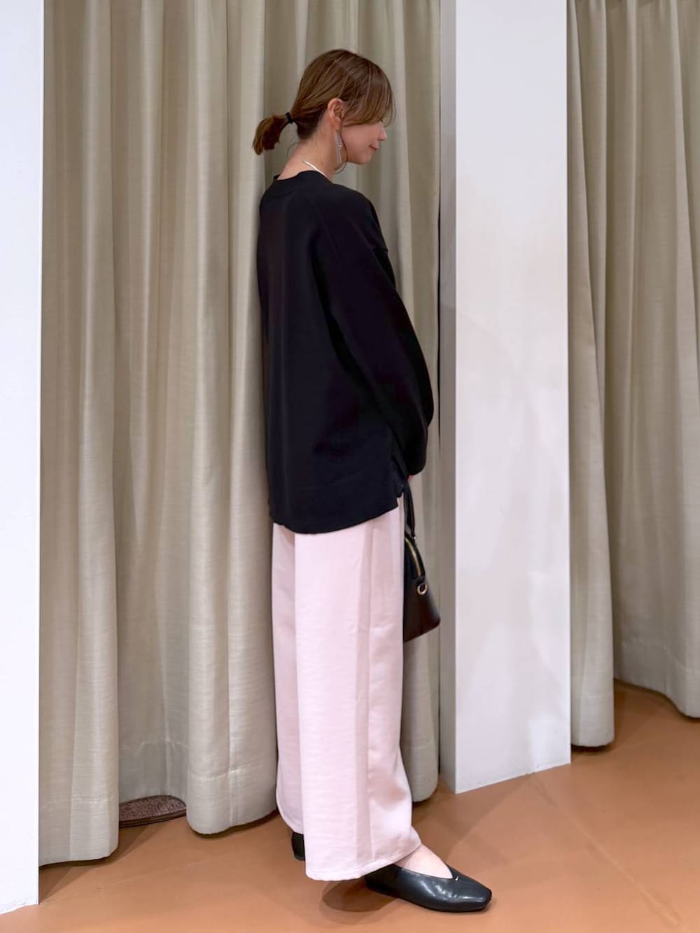 ブラック系のハンドバッグ、ブラック系のパンプス、ブラック系のタンクトップを着用したレディースの冬コーディネートの5枚目の写真