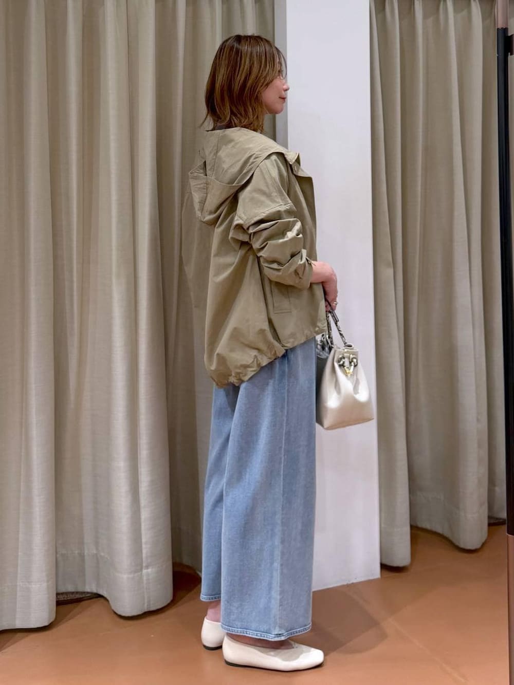 ホワイト系のパンプス、ブルー系のデニムパンツ、ホワイト系のハンドバッグを着用したレディースの春コーディネートの5枚目の写真