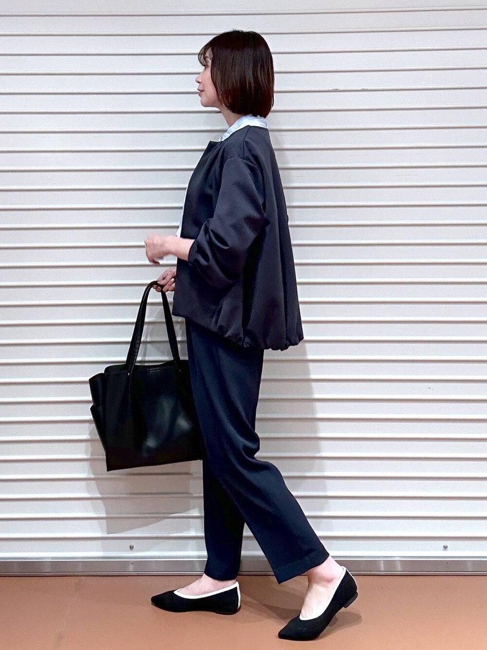 ブラック系のパンプス、ブラック系のトートバッグ、ブルー系のその他パンツを着用したレディースの春コーディネートの3枚目の写真