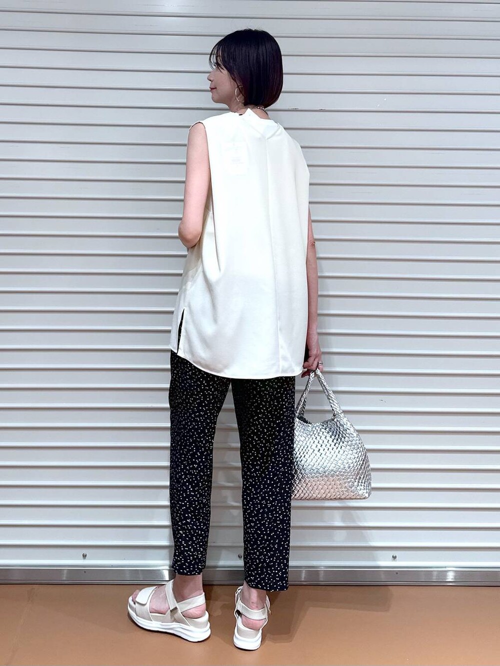 ホワイト系のシャツ/ブラウス、シルバー系のトートバッグ、ホワイト系のサンダルを着用したレディースの夏コーディネートの4枚目の写真