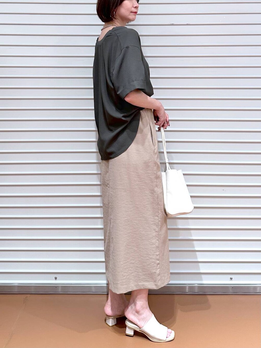 ベージュ系のスカート、グリーン系のシャツ/ブラウスを着用したレディースの夏コーディネートの5枚目の写真