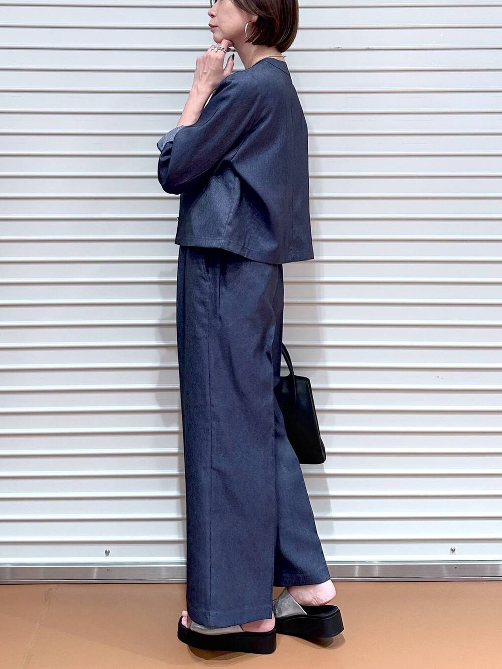 ブラック系のハンドバッグ、シルバー系のサンダル、ブラウン系のタンクトップを着用したレディースの夏コーディネートの6枚目の写真