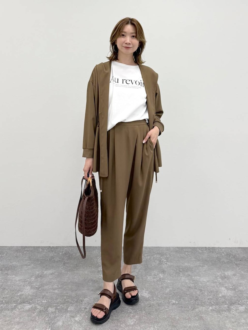 ブラウン系のその他パンツ、ブラウン系のカーディガン/ボレロ、ホワイト系のTシャツ/カットソーを着用したレディースの春コーディネートの2枚目の写真