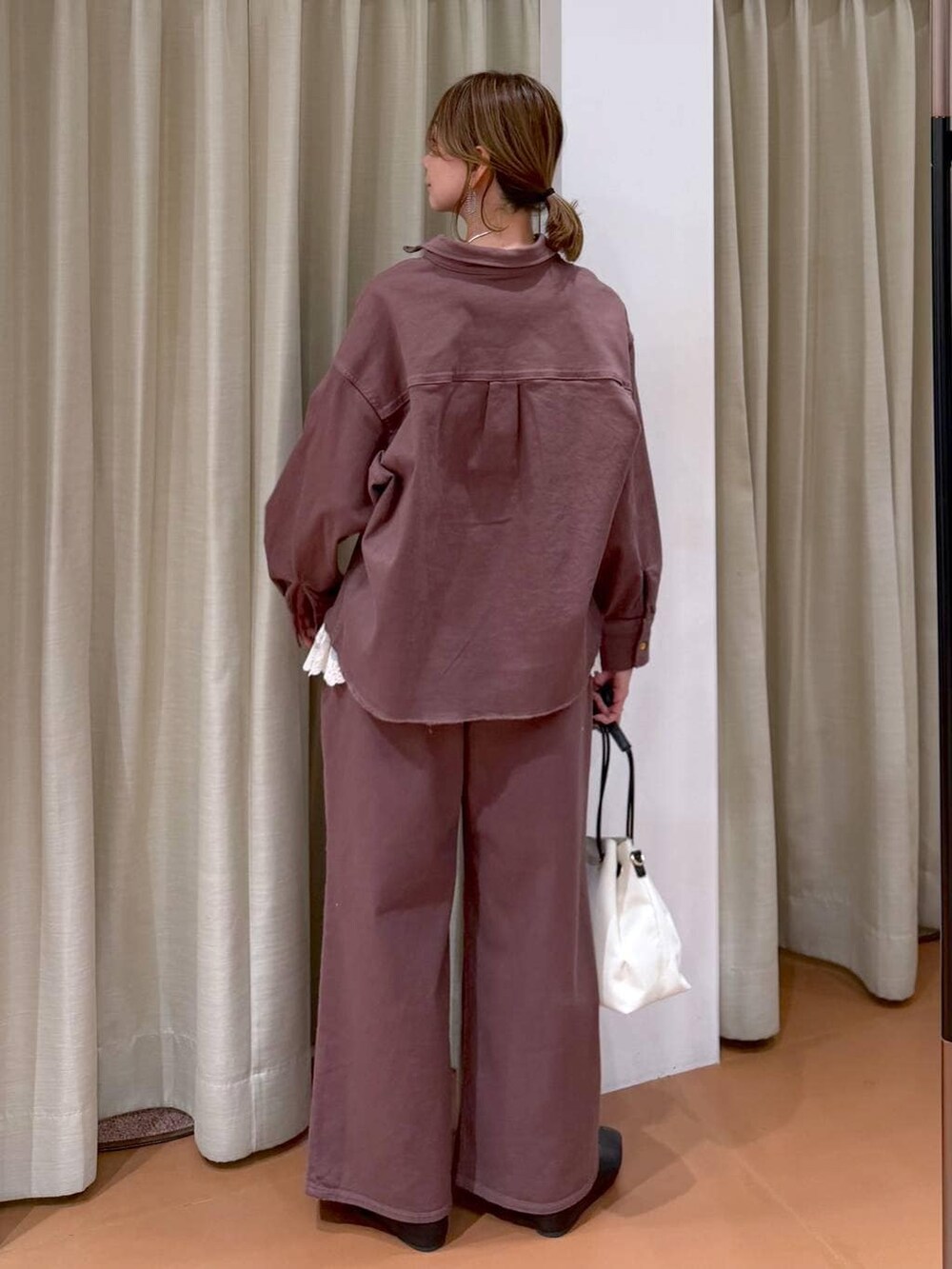 ブラック系のパンプス、ホワイト系のタンクトップ、ブラウン系のデニムパンツを着用したレディースの冬コーディネートの4枚目の写真