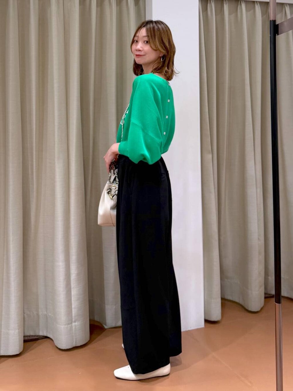 ホワイト系のパンプス、ブラック系のその他パンツ、ホワイト系のハンドバッグを着用したレディースの春コーディネートの3枚目の写真