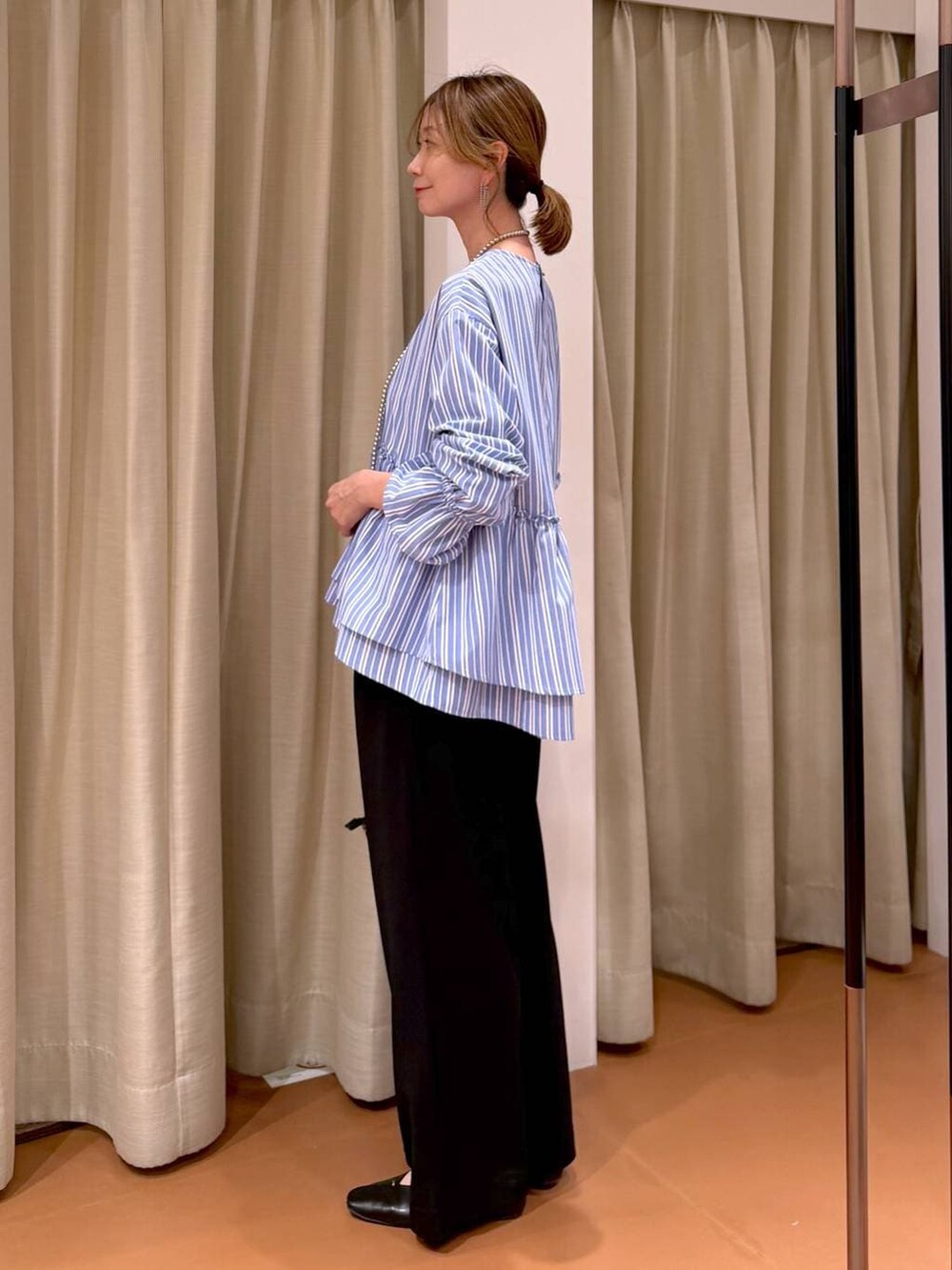 ブラック系のその他パンツ、ブラック系のパンプス、ブルー系のシャツ/ブラウスを着用したレディースの春コーディネートの3枚目の写真