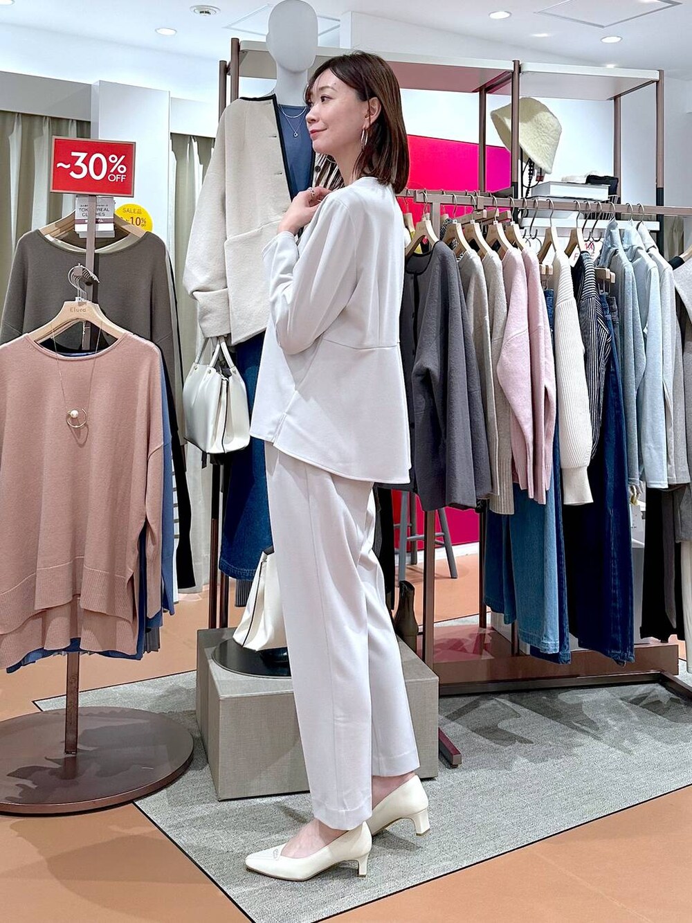ホワイト系のショルダーバッグ、グレー系のシャツ/ブラウス、ホワイト系のパンプスを着用したレディースの冬コーディネートの4枚目の写真
