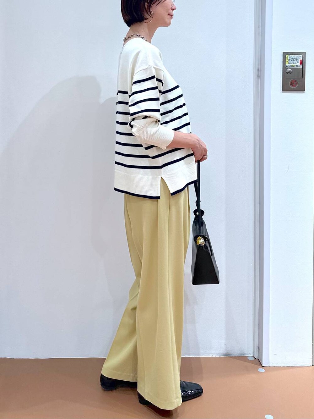 イエロー系のその他パンツ、ブルー系のニット/セーター、ブラック系のパンプスを着用したレディースの冬コーディネートの6枚目の写真