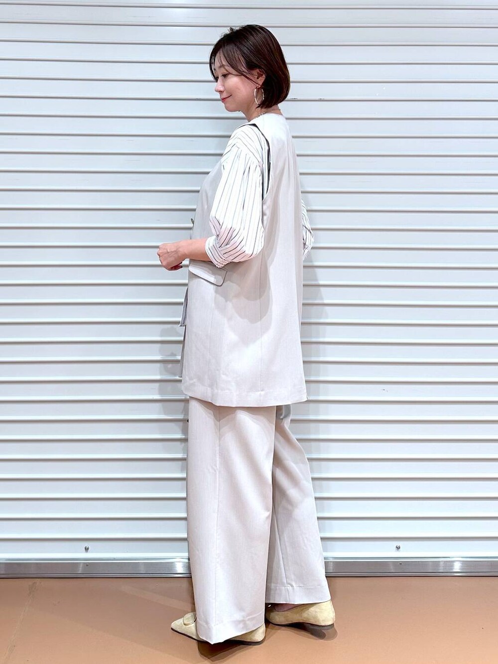 ブラック系のシャツ/ブラウス、ベージュ系のその他パンツ、ベージュ系のベストを着用したレディースの秋コーディネートの3枚目の写真