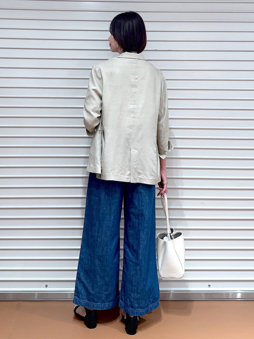 ブルー系のデニムパンツ、ブルー系のデニムパンツ、ブラック系のサンダルを着用したレディースの夏コーディネートの4枚目の写真