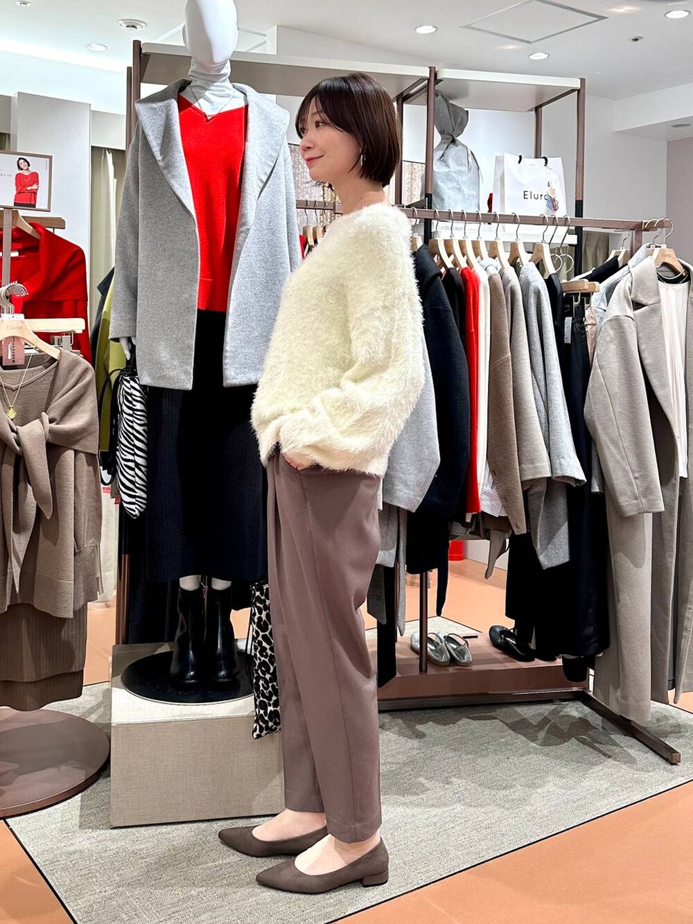 ブラウン系のその他パンツ、ブラウン系のパンプス、ホワイト系のニット/セーターを着用したレディースの冬コーディネートの3枚目の写真