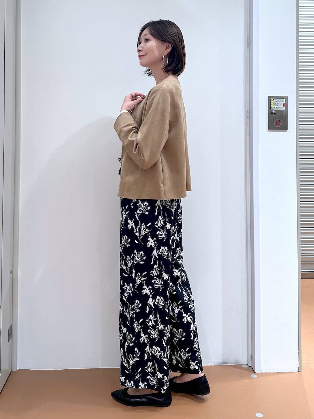 ブラック系のパンプス、ブルー系のその他パンツ、ホワイト系のTシャツ/カットソーを着用したレディースの秋コーディネートの3枚目の写真
